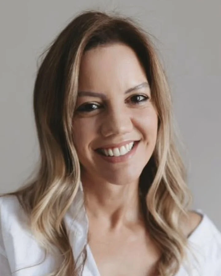 Juliana Fernandes, sorrindo, de camisa branca