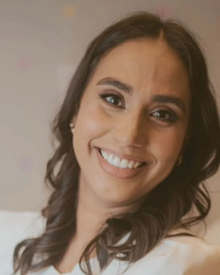 Larissa Nunes, sorrindo, de blusa creme